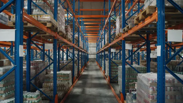 Armazenagem de alimentos e bebidas por lote Corredor de armazém com paletes de alimentos e bebidas em estrutura porta paletes
