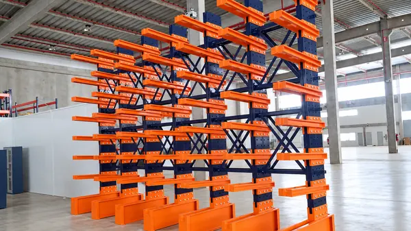 Conjunto de estruturas cantilever com braços laranja em galpão
